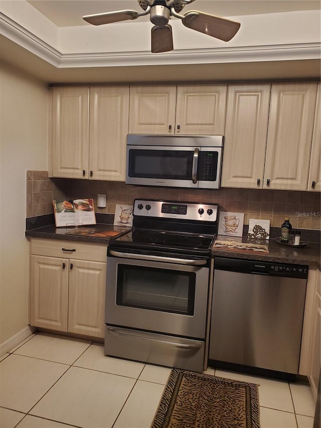 kitchen featuring stainless steel appliances, dark countertops, light tile patterned floors, and tasteful backsplash