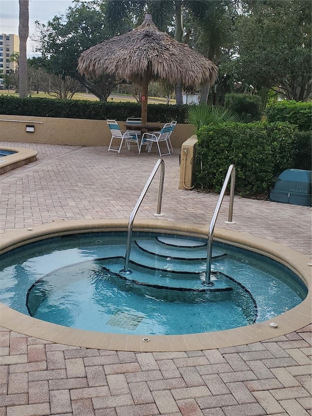 view of pool featuring a community hot tub and a patio area