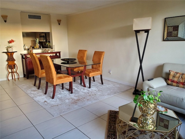 dining area with visible vents, crown molding, baseboards, and light tile patterned floors