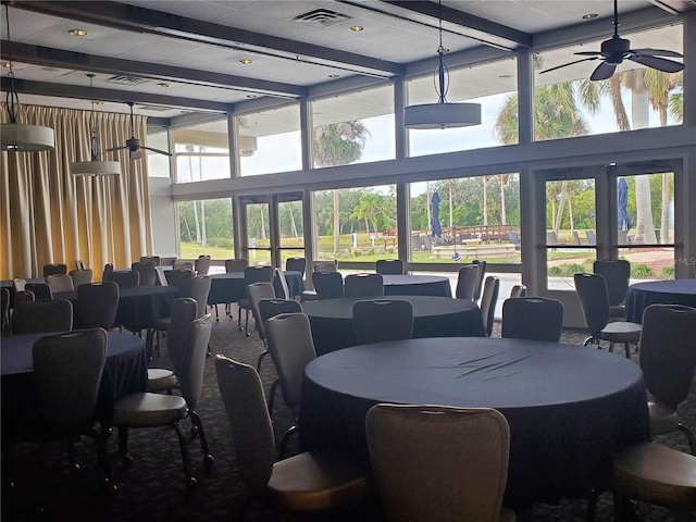 dining area featuring a ceiling fan, visible vents, a wealth of natural light, and beamed ceiling