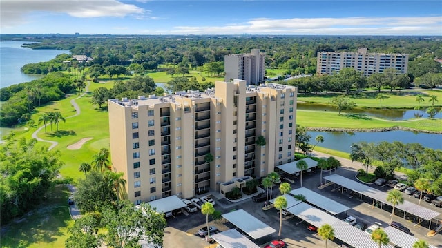 drone / aerial view with view of golf course and a water view