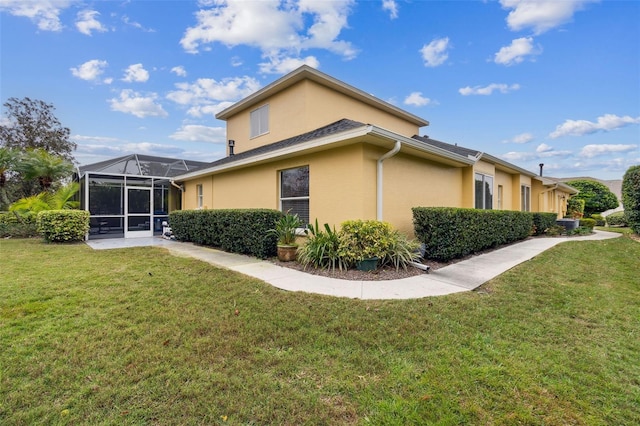 view of side of property featuring a yard and a lanai