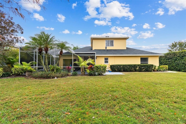 rear view of property with a yard and glass enclosure