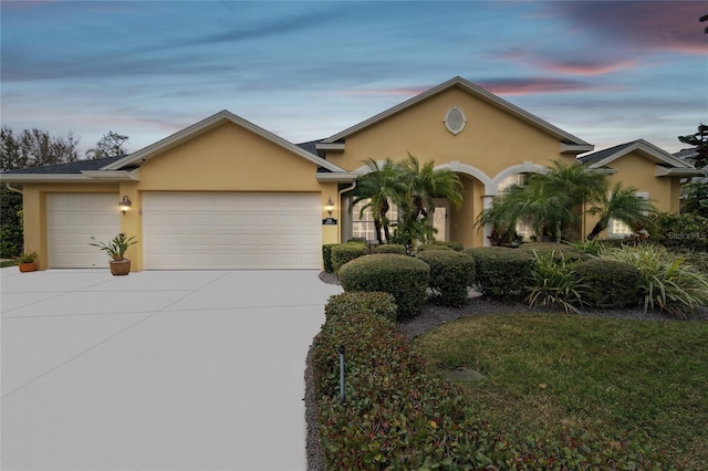 view of front of property featuring a garage and a lawn