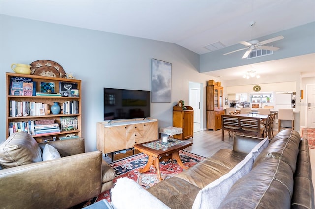 living room featuring ceiling fan, vaulted ceiling, and light hardwood / wood-style flooring