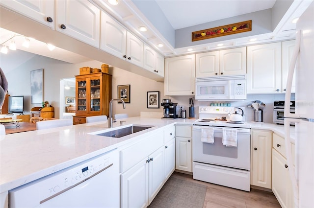 kitchen with white cabinetry, sink, light hardwood / wood-style floors, kitchen peninsula, and white appliances