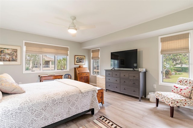 bedroom featuring ceiling fan, multiple windows, and light hardwood / wood-style flooring