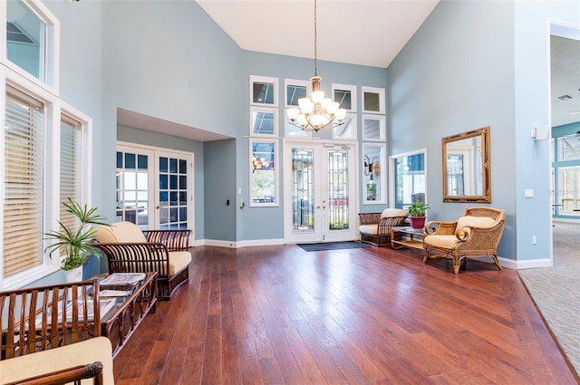 foyer entrance with a towering ceiling, a chandelier, dark hardwood / wood-style floors, and french doors