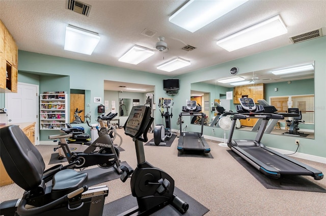 exercise room featuring ceiling fan, carpet, and a textured ceiling