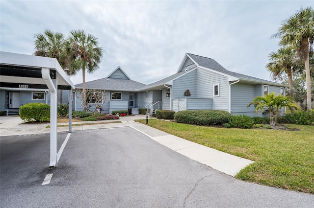 1018 Caravel Ct, Tarpon Springs, FL 34689 - single story home featuring covered and uncovered parking, a front yard, and roof with shingles