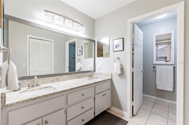1018 Caravel Ct, Tarpon Springs, FL 34689 - bathroom with double vanity, tile patterned flooring, and a closet