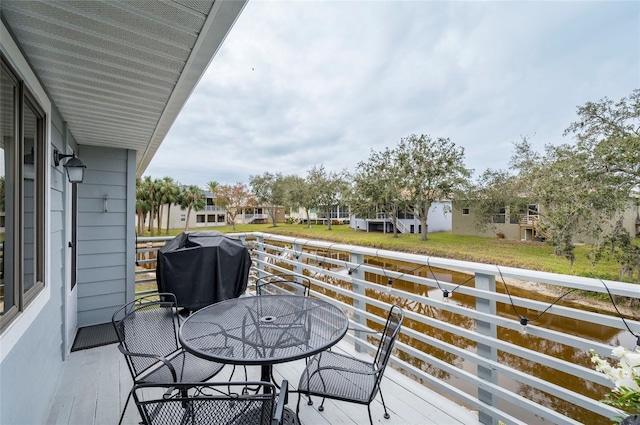 1018 Caravel Ct, Tarpon Springs, FL 34689 - view of wooden balcony with outdoor dining space, area for grilling, a residential view, and a deck