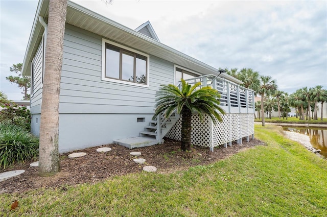 1018 Caravel Ct, Tarpon Springs, FL 34689 - view of side of home featuring a lawn, crawl space, and a deck with water view