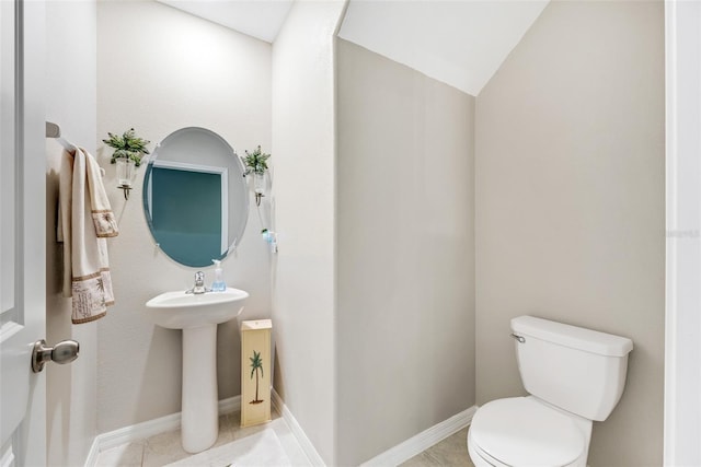 bathroom with toilet, tile patterned flooring, and vaulted ceiling