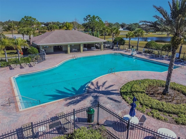 view of pool featuring a water view and a patio