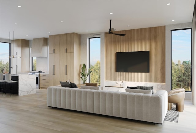 living room featuring ceiling fan and light hardwood / wood-style floors