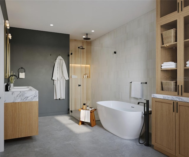 bathroom featuring shower with separate bathtub, vanity, and tile walls