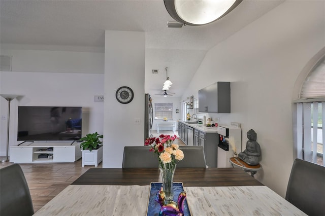 dining room with lofted ceiling, ceiling fan, and sink