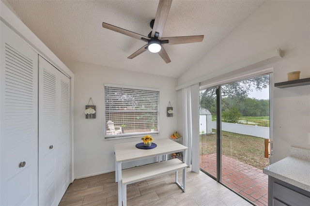 dining room featuring ceiling fan, a textured ceiling, and lofted ceiling