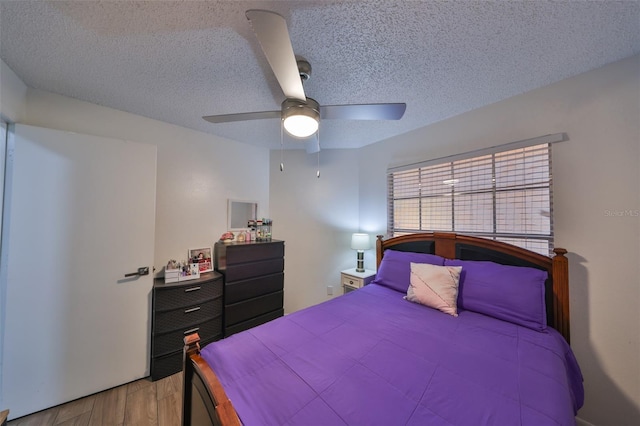 bedroom featuring ceiling fan, a textured ceiling, and light hardwood / wood-style flooring