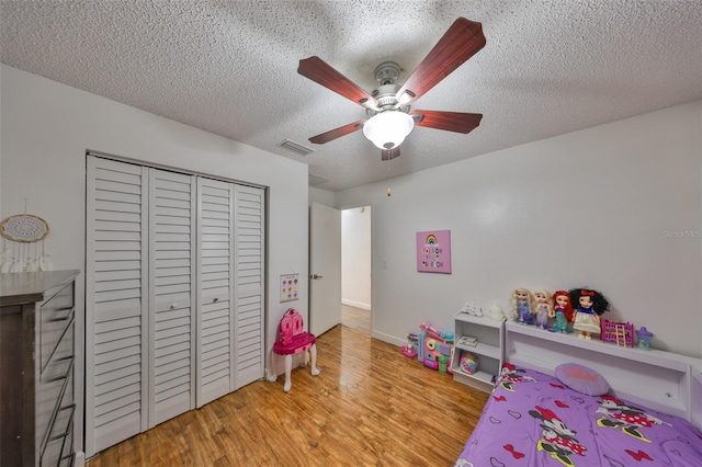 playroom with ceiling fan, light wood-type flooring, and a textured ceiling