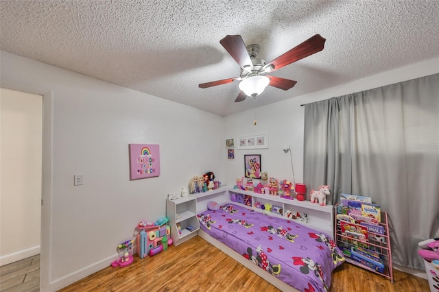 bedroom with ceiling fan, a textured ceiling, and hardwood / wood-style flooring