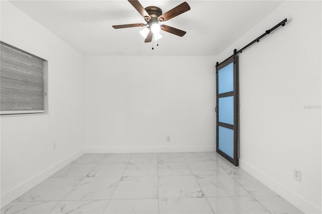 unfurnished room with a barn door and ceiling fan