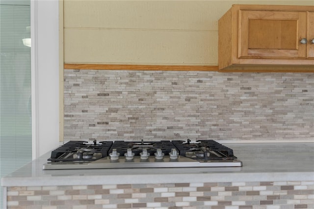 interior details with stainless steel gas stovetop and decorative backsplash