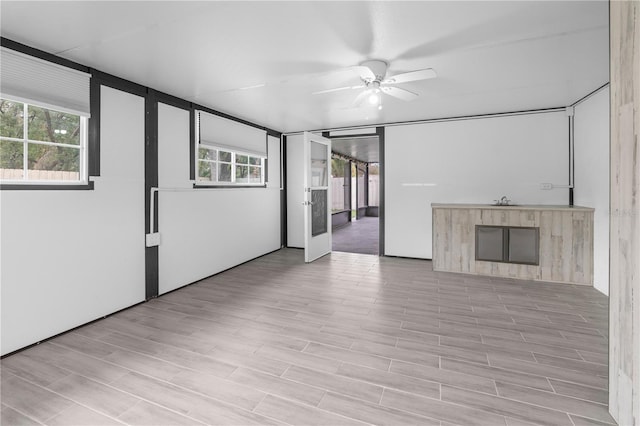 unfurnished living room with light hardwood / wood-style flooring, a fireplace, and ceiling fan