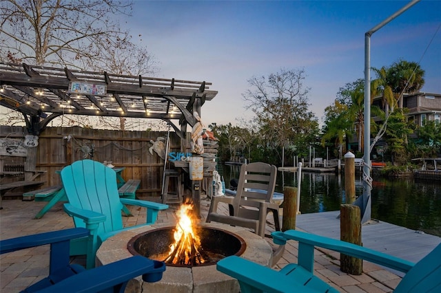 exterior space featuring a water view and an outdoor fire pit