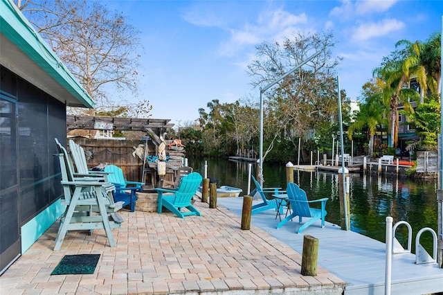 view of patio / terrace featuring a water view, a dock, and an outdoor fire pit