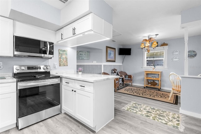 kitchen with stainless steel appliances, white cabinets, light wood-type flooring, and kitchen peninsula