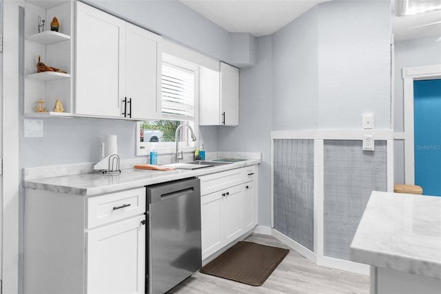 kitchen with sink, white cabinetry, dishwasher, light stone countertops, and light hardwood / wood-style floors