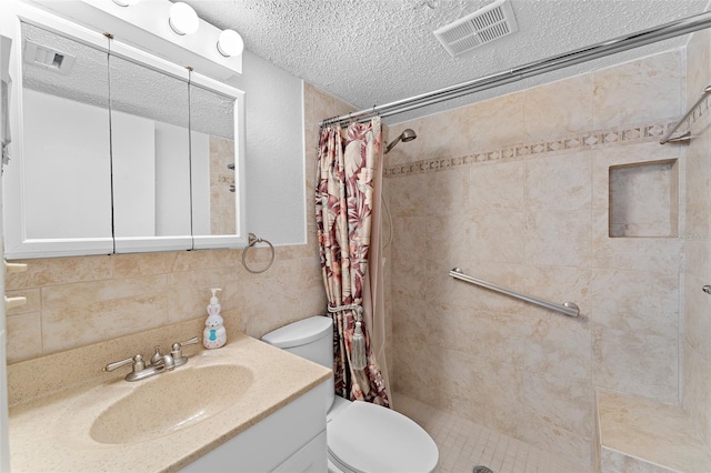 full bath featuring visible vents, toilet, a tile shower, a textured ceiling, and tile walls