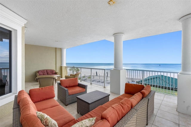 balcony featuring a beach view, outdoor lounge area, and a water view