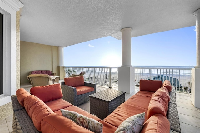 balcony featuring a water view, a beach view, and outdoor lounge area