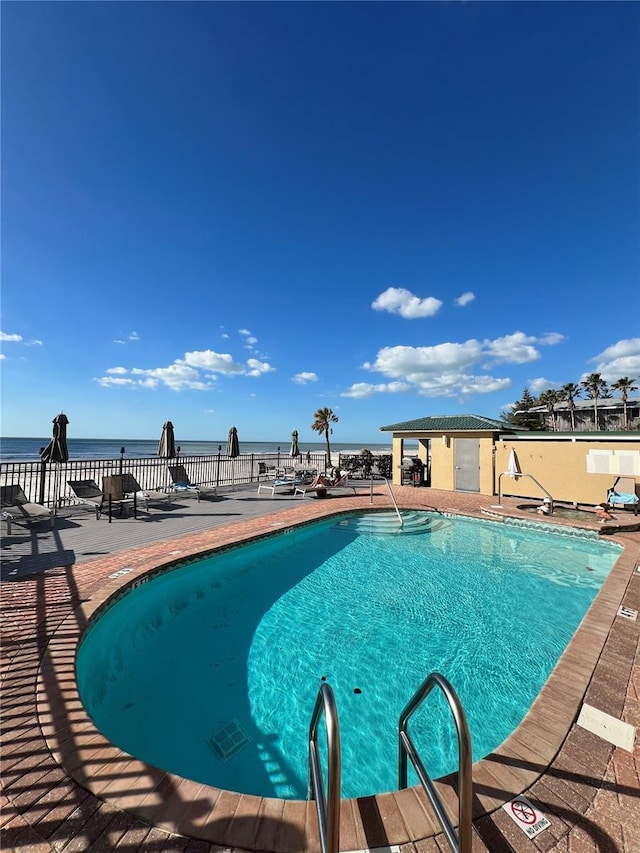 community pool with a water view and a patio