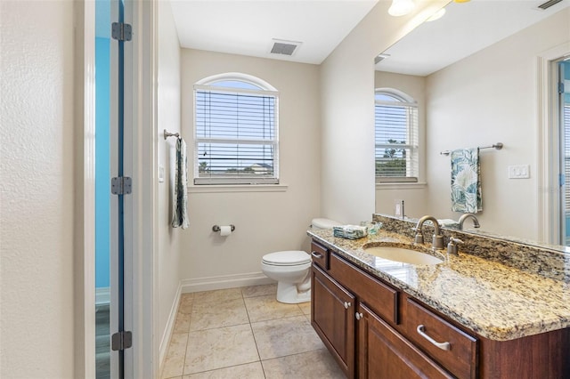 bathroom with toilet, vanity, baseboards, visible vents, and tile patterned floors