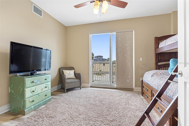 bedroom featuring baseboards, access to outside, visible vents, and wood finished floors