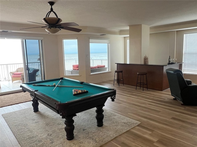 recreation room with ceiling fan, a textured ceiling, wood finished floors, and pool table