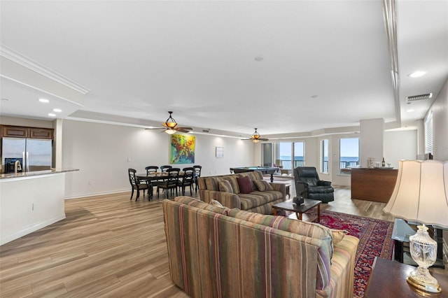 living area with recessed lighting, visible vents, ceiling fan, light wood-type flooring, and baseboards