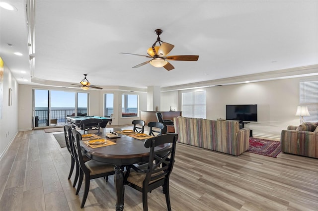 dining space featuring a ceiling fan, light wood-style flooring, and baseboards