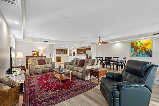 living area with light wood finished floors, visible vents, a ceiling fan, and recessed lighting