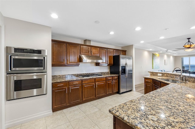 kitchen featuring recessed lighting, appliances with stainless steel finishes, stone countertops, a sink, and under cabinet range hood