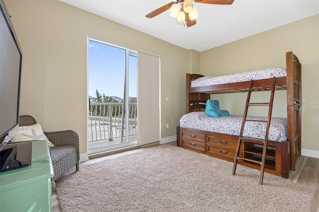 bedroom featuring baseboards, wood finished floors, a ceiling fan, and access to exterior