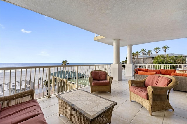 exterior space with a water view, an outdoor living space, and a view of the beach