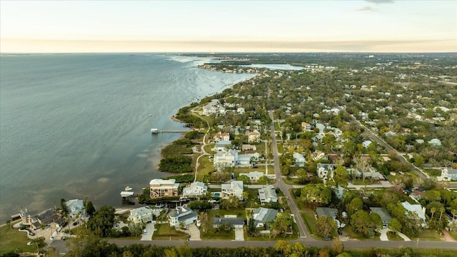 aerial view at dusk featuring a water view