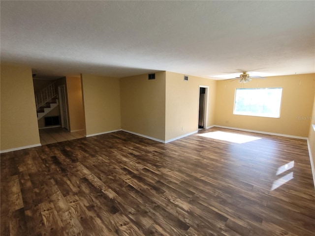 empty room featuring dark wood-type flooring and ceiling fan