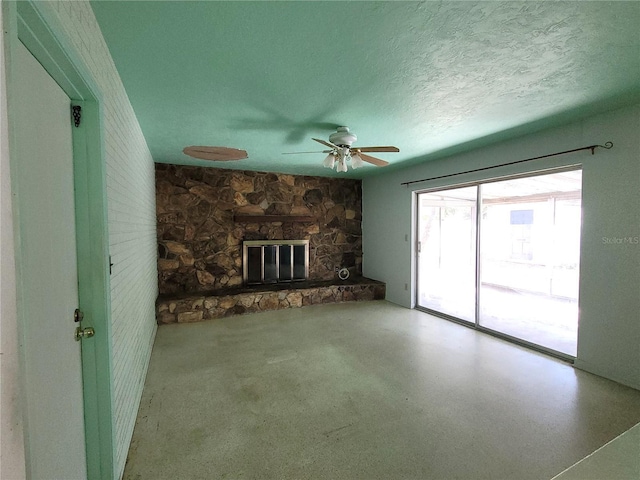 unfurnished living room with a stone fireplace and a textured ceiling