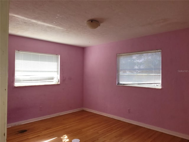 unfurnished room with wood-type flooring